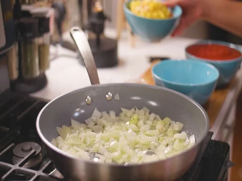 Dumping peppers in a frying pan Stock Footage