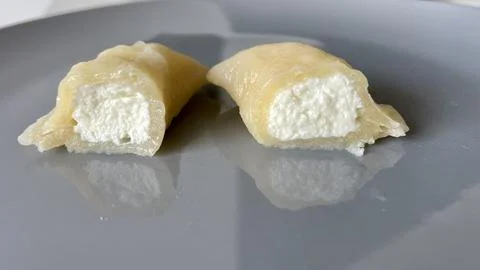 Dumpling with cheese cut in half on a gray plate Foto stock