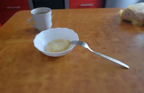 Dumpling in a light bowl next to a cup of tea coffee bread on the table fork Stock Photos