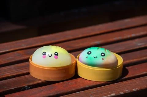 Dumpling squishy toys in steamer boxes on a wooden bench Stock Photos