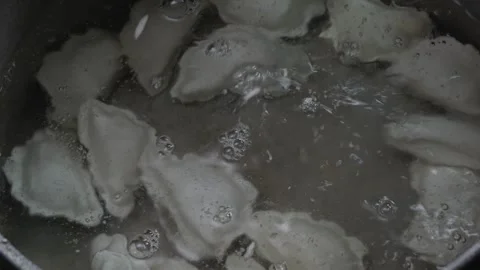 Dumplings and dumplings fall into boiling water in a pan Stock Footage 258957420