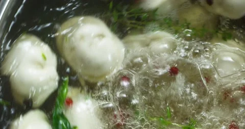 Dumplings are boiled in pot with boiling water with spices and spin on closeup Stock Footage 152094202