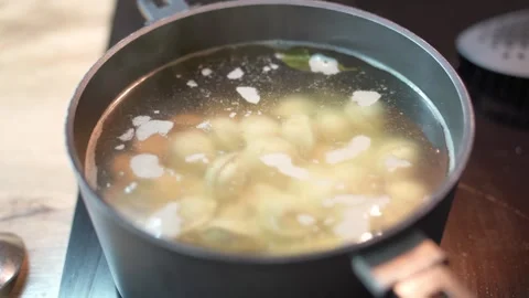 Dumplings are cooked in boiling water with salt and spices in a saucepan. 库存影片 329922148