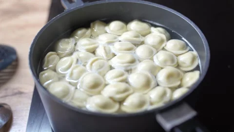 Dumplings are cooked in boiling water with salt and spices in a saucepan. Stock Footage 329922267