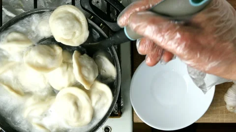 Dumplings are take from cooking pan with boiling water with skimmer. Stock Footage 130504657