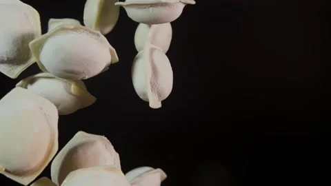Dumplings fly up and fall close up with selective focus and slow motion. Stock Footage 280685834