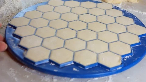 Dumplings get enough sleep on the table. A woman sculpts dumplings using a Stock Footage 128056853