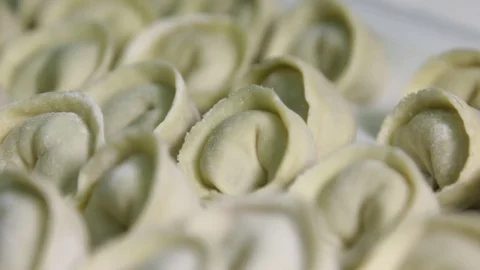 Dumplings with meat lie in rows on a tray, close-up, production of ravioli Stock Footage 75255094
