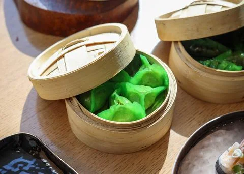 Dumplings momo on green leaf inside wooden bowl Stock Photos