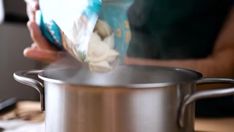 Dumplings from the pack quickly tend to a pot of hot water. 스톡 동영상 250309983