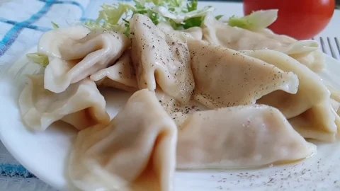 Dumplings on a plate fall on peppers Stock Footage 89711130