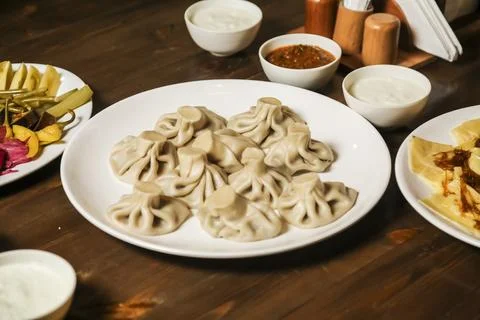 Dumplings served on a plate with various accompaniments at a restaurant Stock Photos