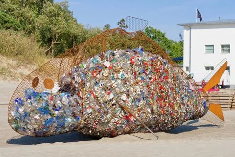 Dumpster in the form of a huge fish with garbage inside. Stock Photos