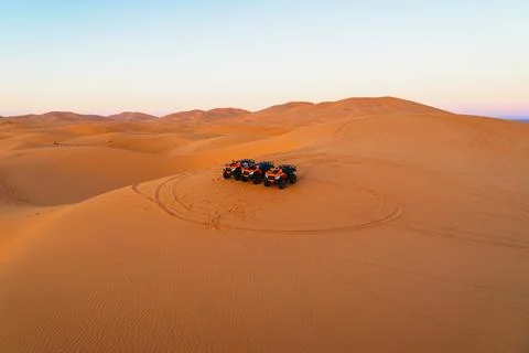 Dune adventure at sunset with multiple ATVs parked in the serene Sahara des.. Stock Photos