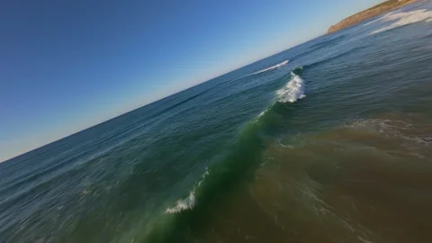 Dune-covered coastline with ocean waves crashing onto shore Stock Footage 344558864