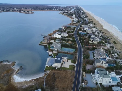 Dune Road threading a narrow barrier beach past the bay Stock-Footage 83013885