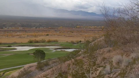 Dunes overlook desert golf course with foggy mountains in distance Stock Footage 125344014