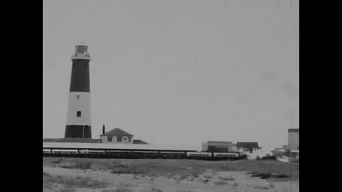 Dungeness, England, 1970 - Train restarts from the station near old lighthouse 库存影片 167652053