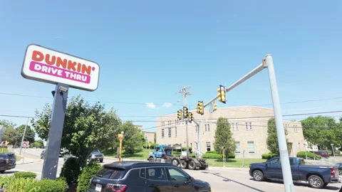 Dunkin' Donuts sign by side of road with traffic. USA. Stock Footage 278973804