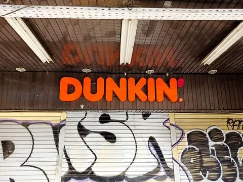 Dunkin Storefront With Graffiti-Covered Shutters Фото