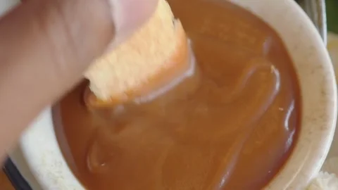 Dunking bread in sweet sauce for a tasty treat Stock Footage 335380715