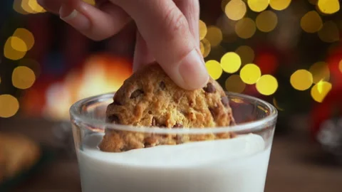 Dunking a Chocolate Chip Cookie in Glass of Milk in Slow Motion on Christmas Stock Footage 208931411
