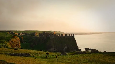 Dunluce Castle in warm evening light during sunset, Northern Ireland Stock Footage 64208562