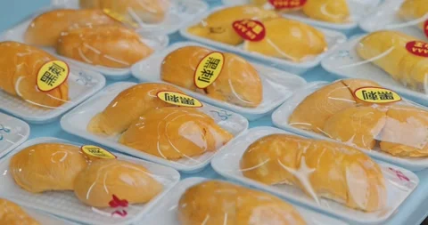 Durian fruit packaged in plastic trays, displayed on market shelf 스톡 동영상 343059235
