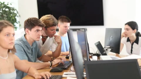 During computer lesson, male teacher helps guy student complete difficult task, Stock Footage 258877006
