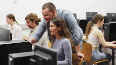 During computer lesson, male teacher helps girl student complete difficult task 스톡 동영상 322112994