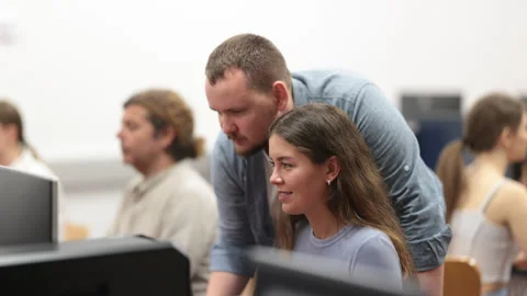 During computer lesson, male teacher helps girl student complete difficult task Stock Footage 329399062