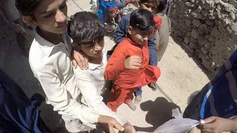 During Corona lockdown man from an NGO distributes food to poor children wearing Vídeo Stock 129176894
