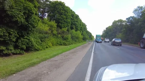 During the day, road construction is taking place in a forested area, while vehi Video stock 347162503