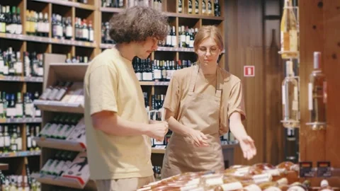 During a discussion in a liquor store, a customer and store clerk seek advice to Stock Footage 301102700