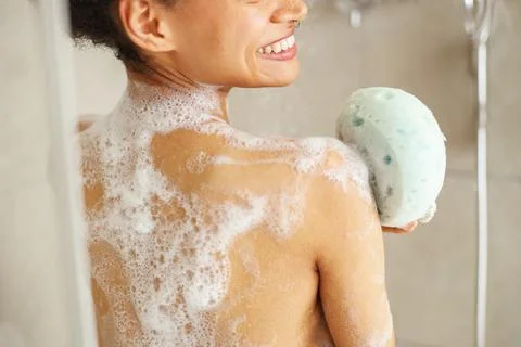 During the event of bathing, she washes her back with a sponge Stock Photos