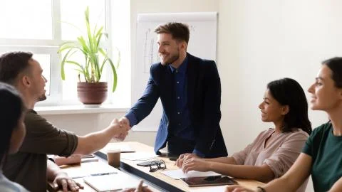 During group meeting male leaders shaking hands greeting each other Stock Photos