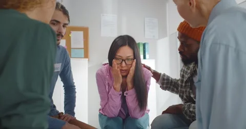 During group therapy session participants supporting crying desperate asian Stock Footage 154126311