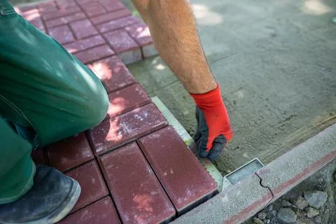 During the laying of paving blocks, the worker checks with a protractor, the Foto stock