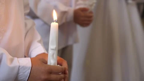 During the liturgy dedicated to the First Holy Communion of children, a boy hold Stock Footage 244919577