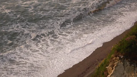During sunset, powerful ocean waves crashing on beach in slow motion Stock Footage 247508540