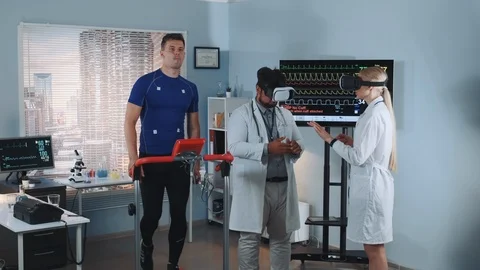 During the treadmill test two mixed race doctors in VR glasses speaking about Stock Footage 114081423