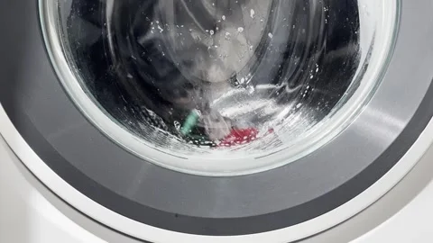During the wash cycle the drum repeatedly rotates and pauses, with water an.. 動画素材 322215966
