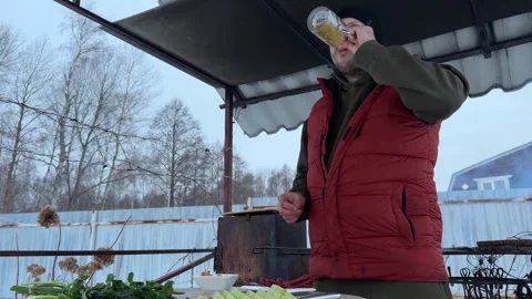 During winter, a man enjoys delicious cooking on his barbecue grill Vidéo 311925268