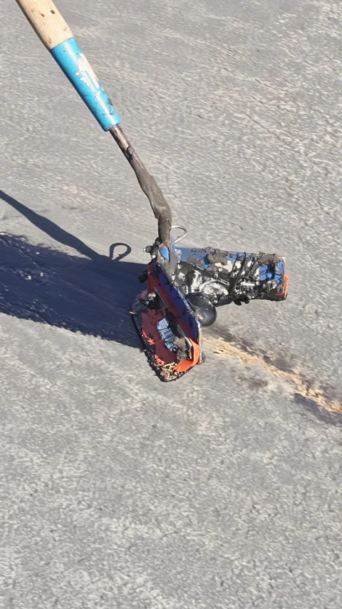 During worker patcher performs coated filling asphalt cracks sealing bitumen Stock Footage 262158319