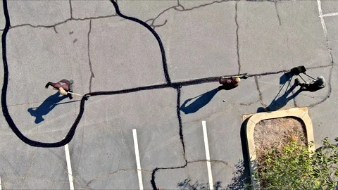 During worker patcher performs coated filling asphalt cracks sealing bitumen Stock Footage 275345038