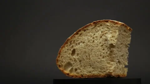 Durum wheat bread on a rotating plate on a black background Vídeo Stock 134062294
