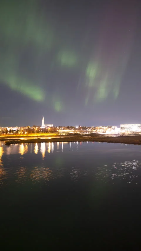 Dusk aurora borealis mirror reflection water Reykjavik Iceland vertical format Stock Footage 327499341