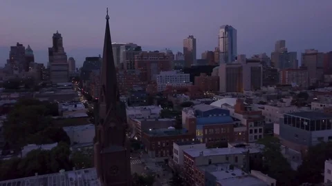 Dusk counter clockwise orbiting Brooklyn church revealing Manhattan skyline Stock Footage