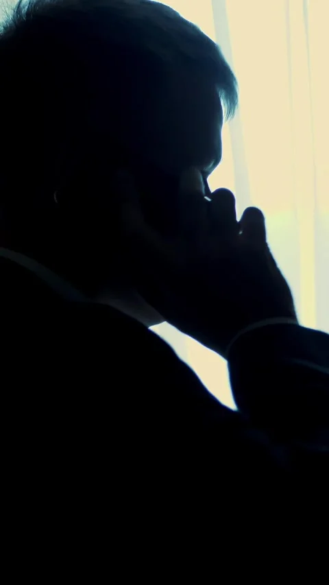 At dusk, in darkness, opposite window. handsome man, businessman in white shirt Stock Footage 317850326