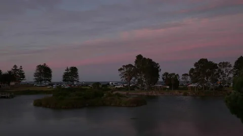 Dusk develops above picturesque waterway surrounding small island Time Lapse Stock Footage 229457468
